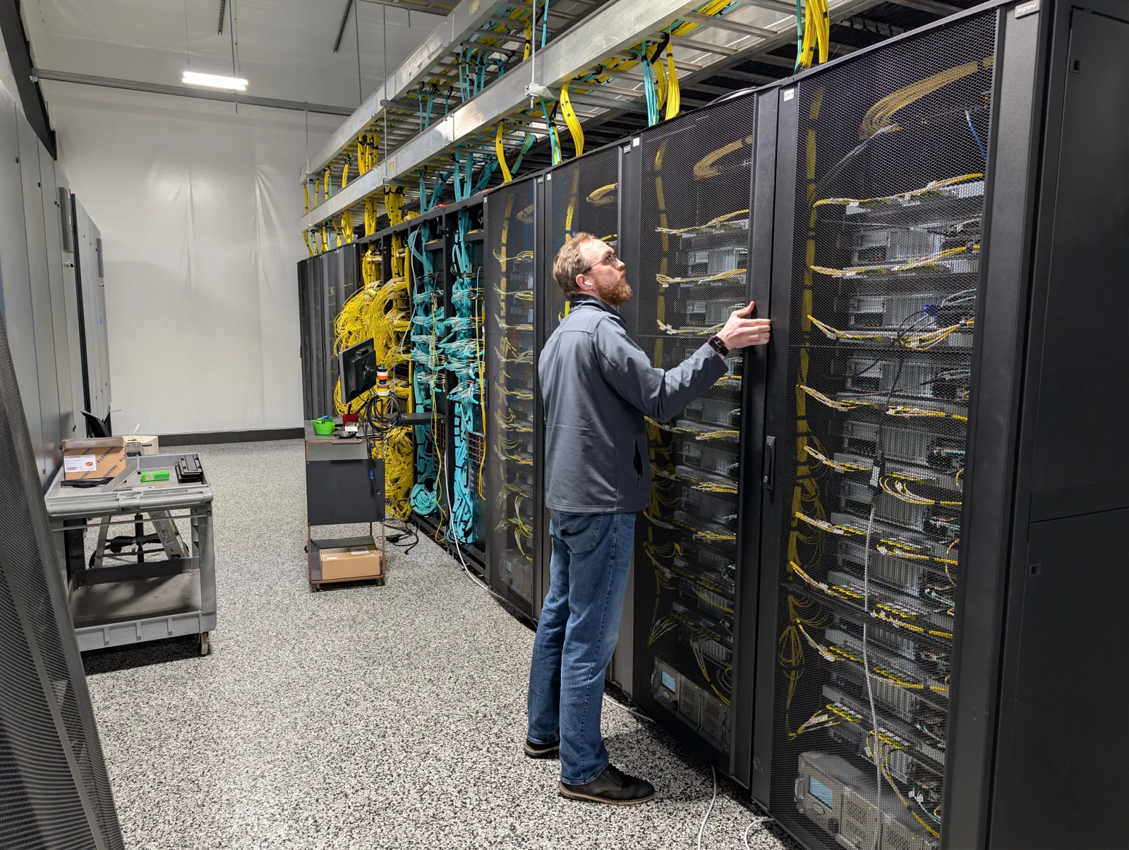 Person working at compute racks during a B300 infrastructure deployment